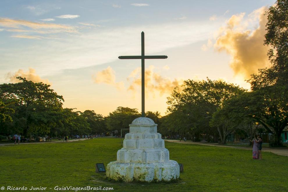 Imagem de um crucifixo no meio do gramado na praça em Quadrado, Trancoso.